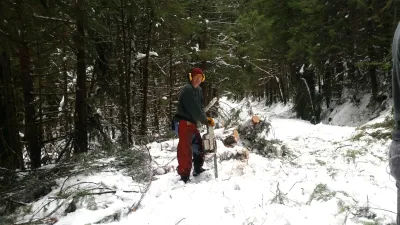 John Moreau, post retirement, helps clear trees from the 1506 Road