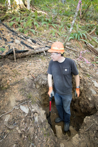 Hatten cleaning off a soil pit so it can be sampled and photographed